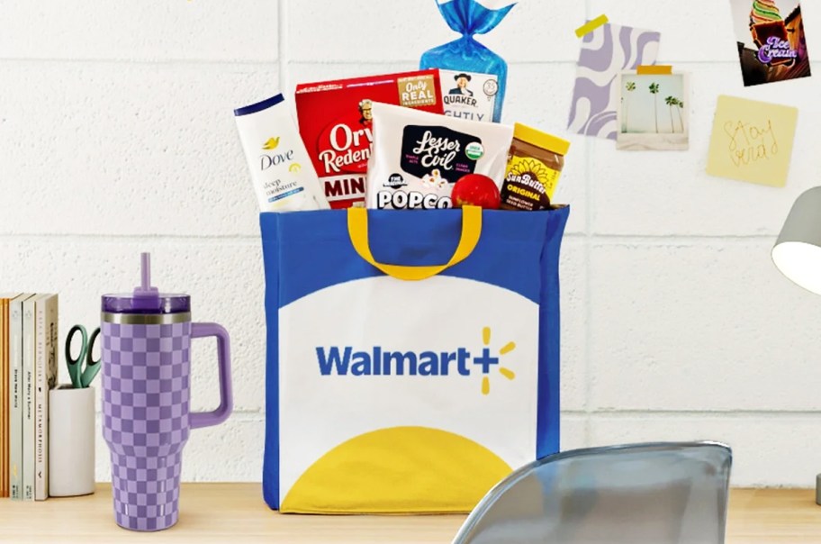 walmart+ bag filled with groceries on a desk near a purple tumbler