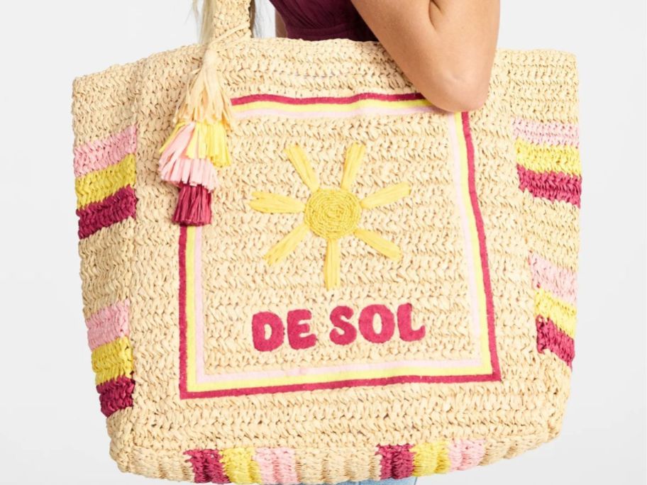 Woman holding Walmart's woven No Boundaries Beach Tote