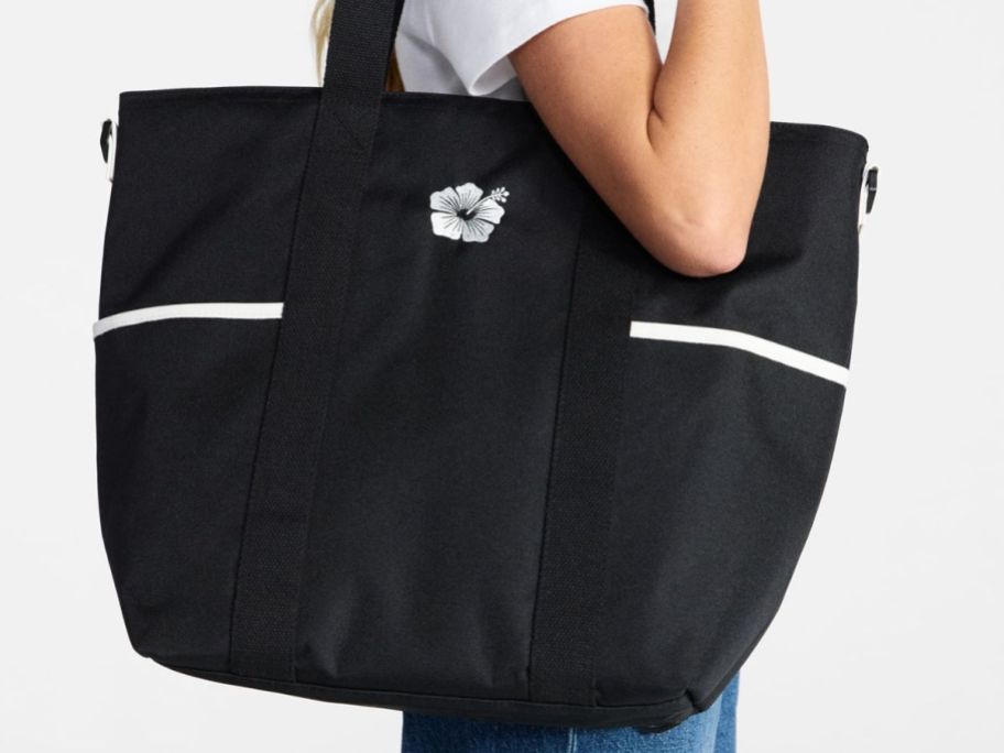 Woman holding black No Boundaries insulated tote bag