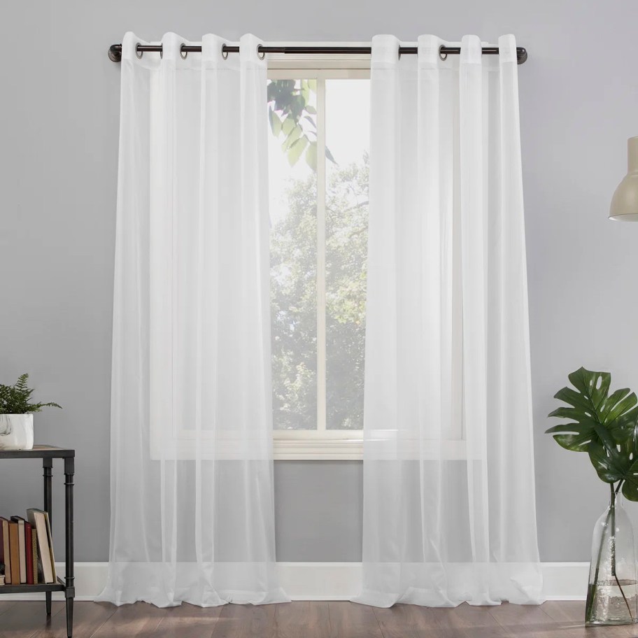 To sheer white curtain panels hanging from window