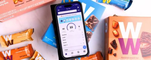 Weight Watchers App on a phone with prepackaged ww treats around it