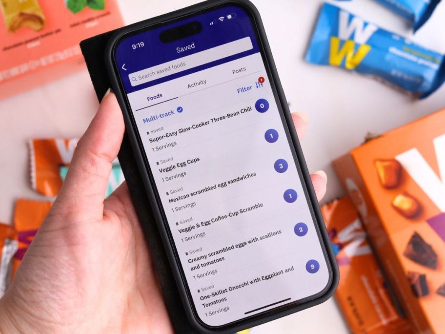 Hand holding mobile phone with Weight Watchers app installed