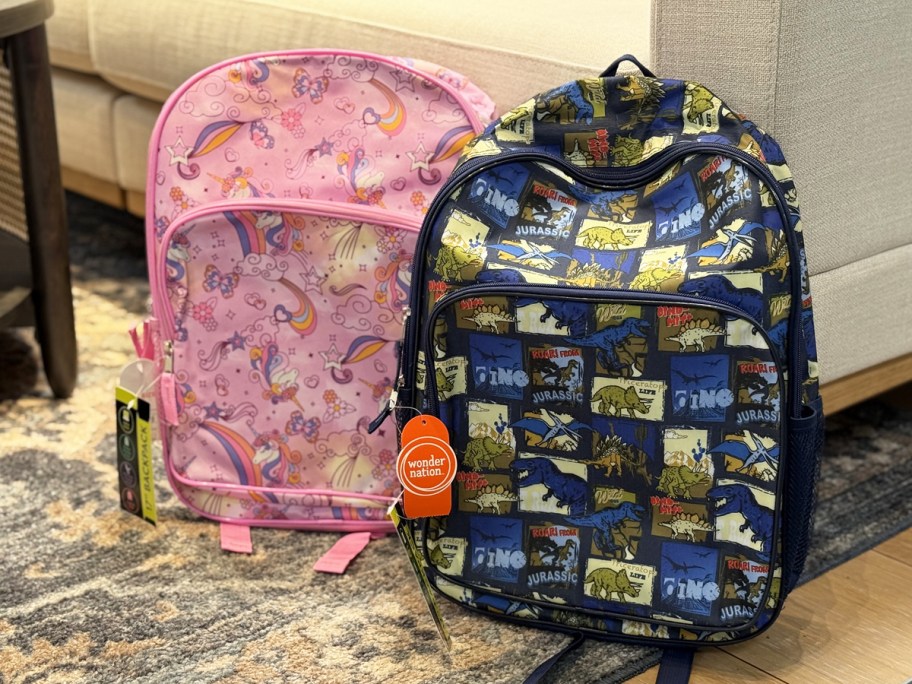 unicorn and dinosaur print backpacks near a couch