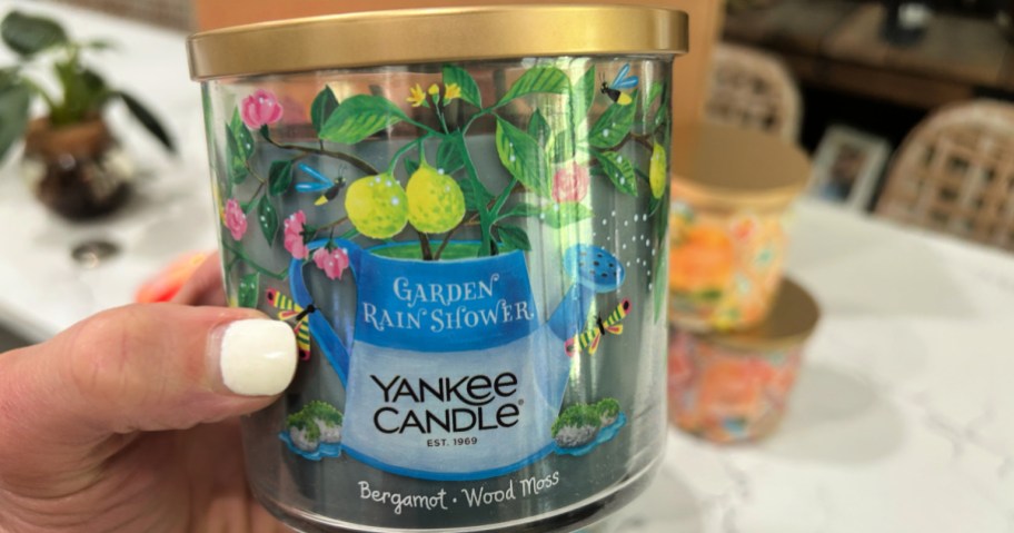 person holding up Yankee candle bergamot candle