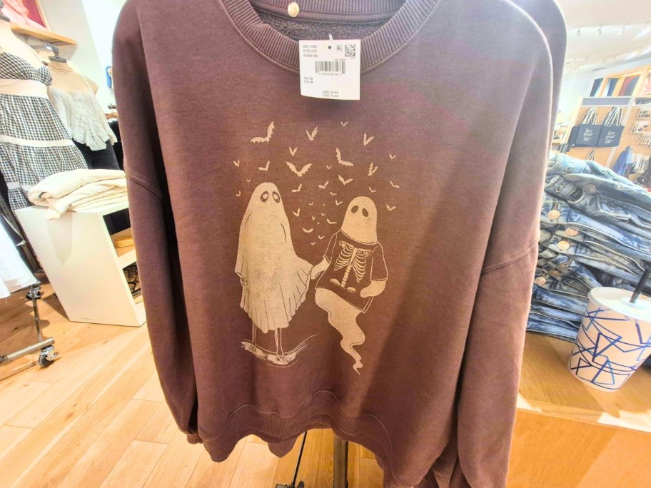 a Halloween sweatshirt with ghosts on it in a store