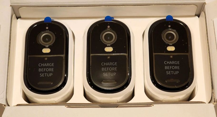Three arlo cameras inside of their boxes