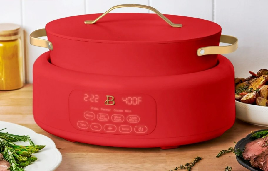 red multicooker on table with lid