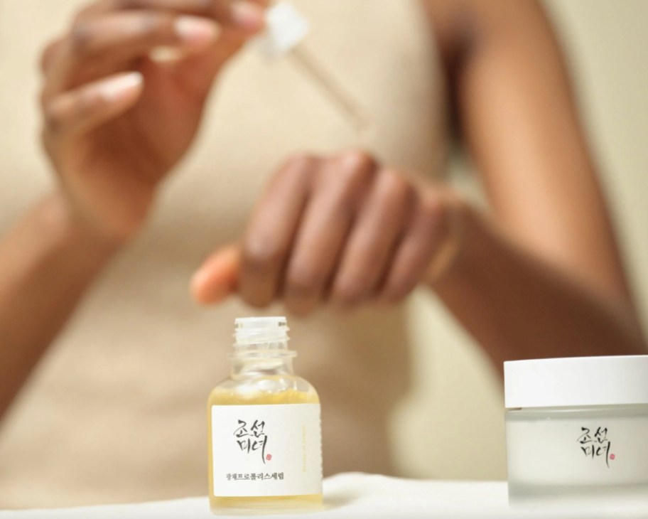 woman applying serum drops to arm