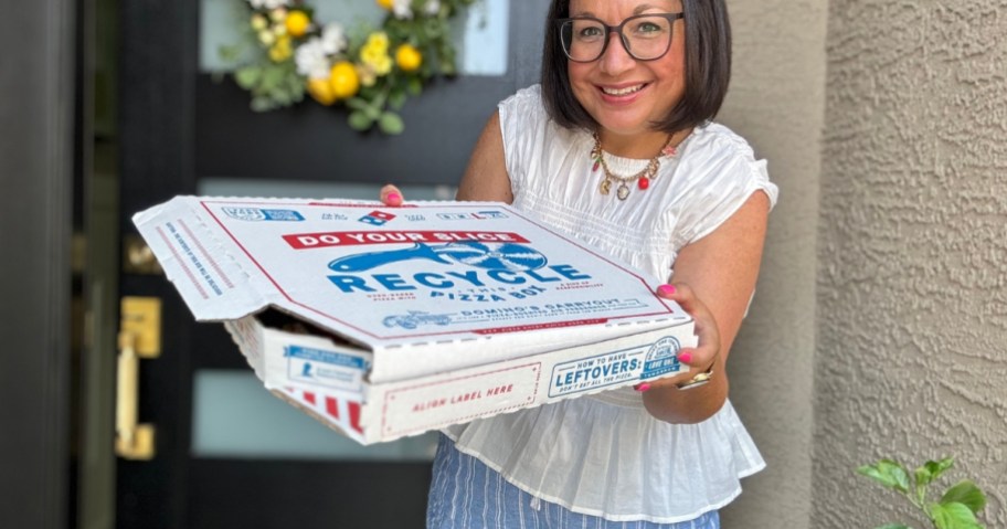 Woman holding large pizza