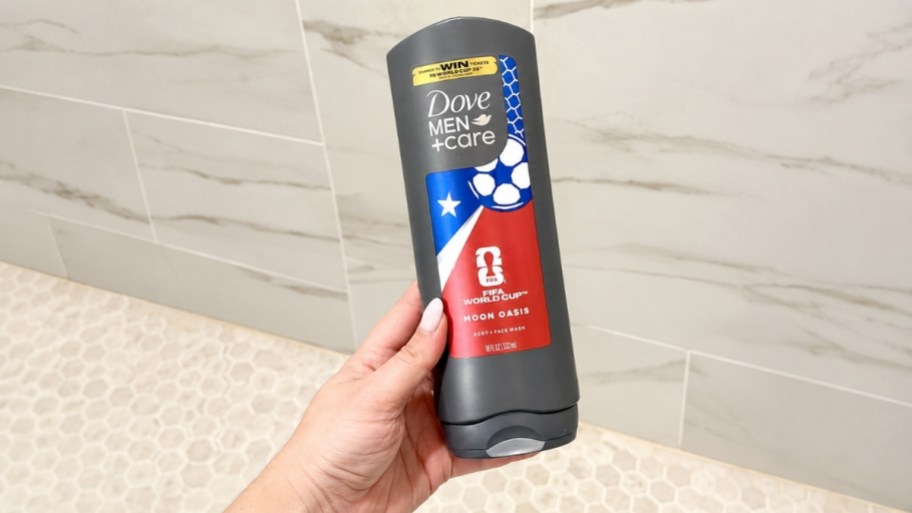 womans hand holding a bottle of body wash