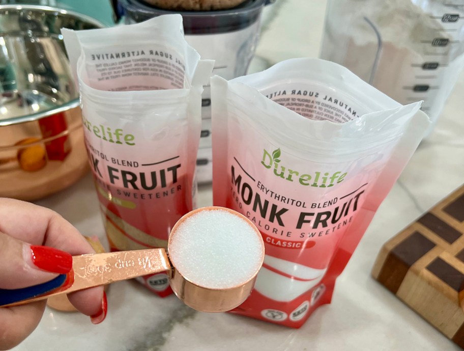 person showing a scoop of durelife monk fruit sweetener
