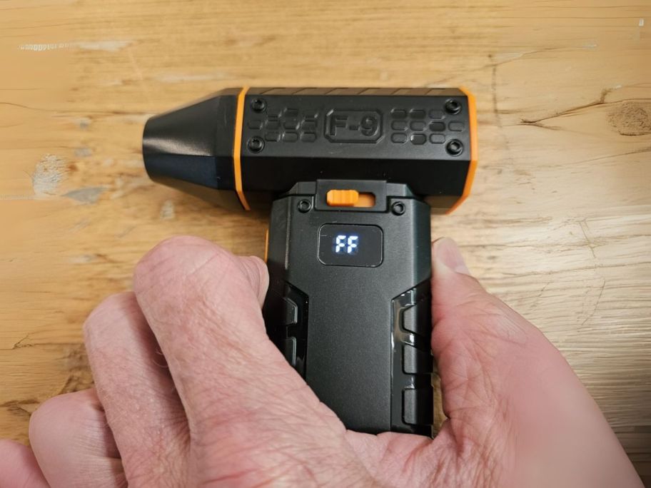 mini air duster in hand on table