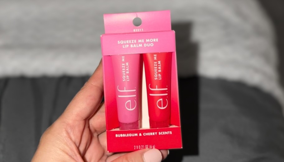 a woman holding a two pack of elf lip balms