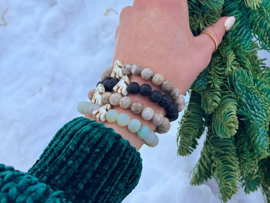 woman wearing fahlo bracelets on wrist while holding wreath