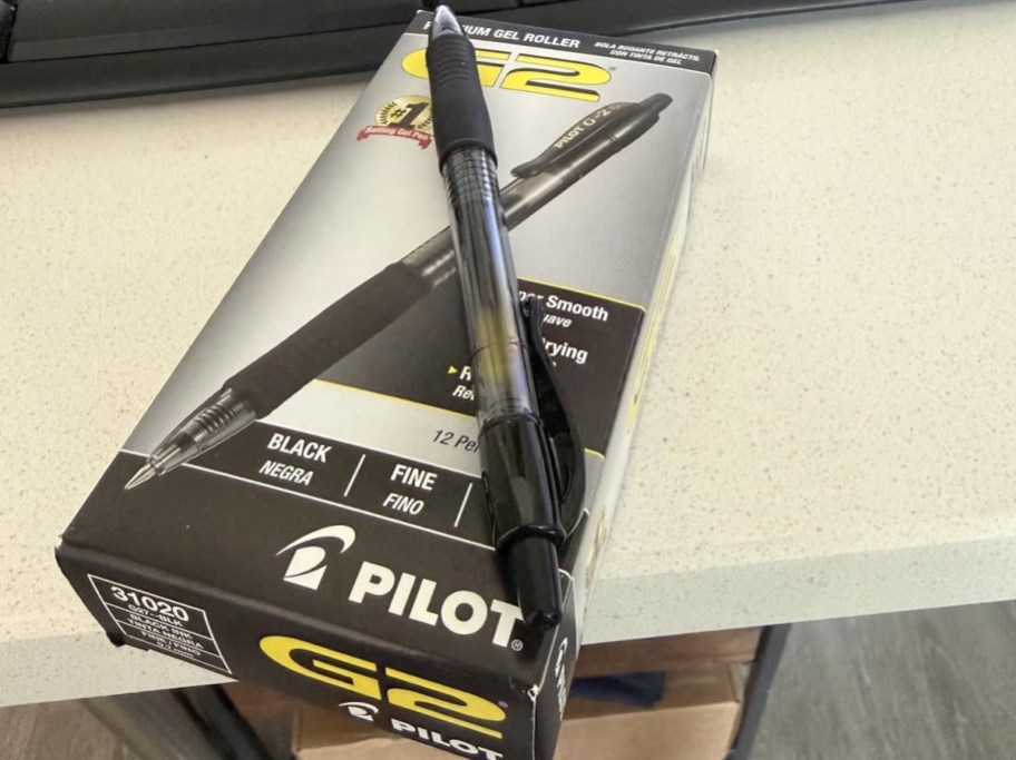 box of black g2 pens in box on desk