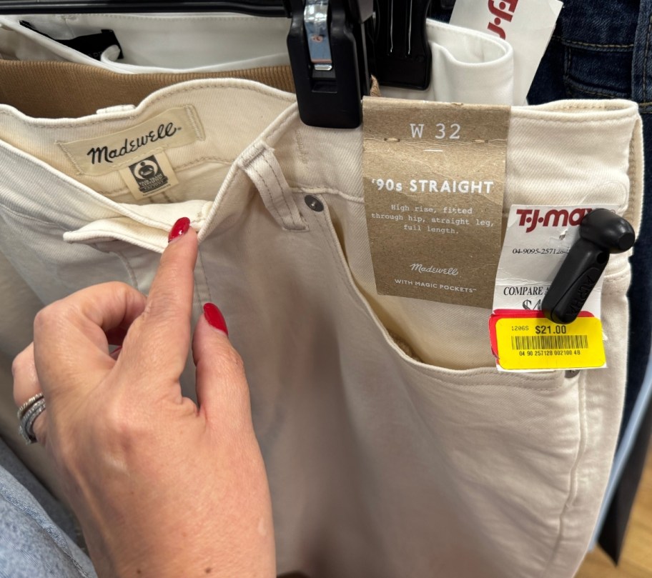 womans hand holding the waistband of a pair of jeans