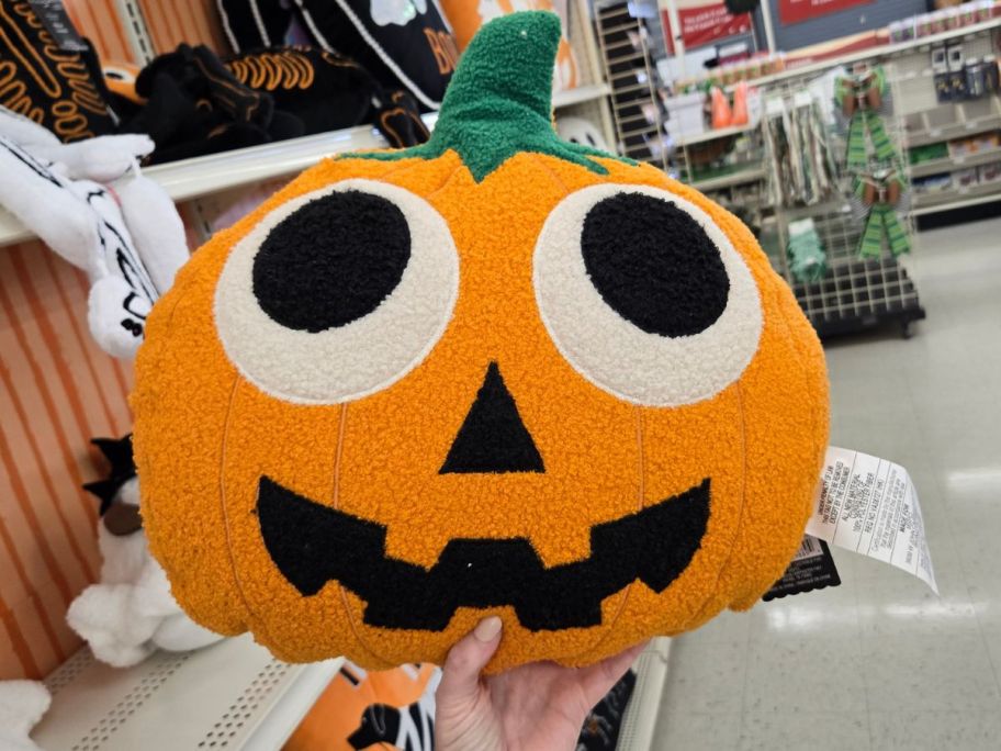 Silly Orange Pumpkin Face Pillow in hand in store
