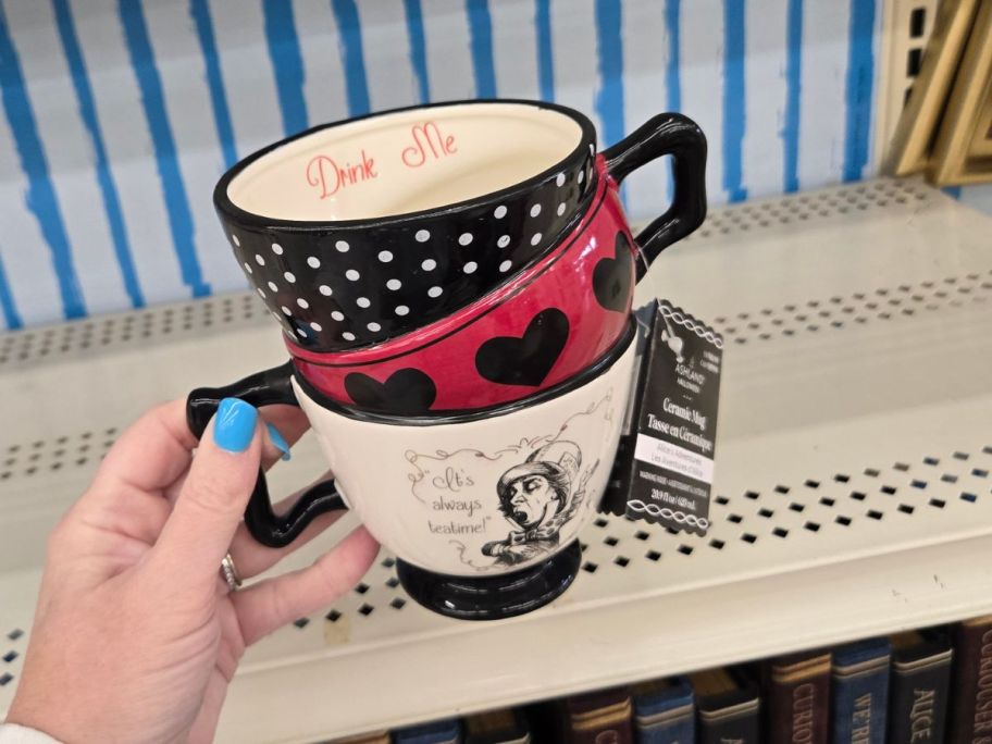 Mad Hatter Teacup Trio Ceramic Mug in hand in store