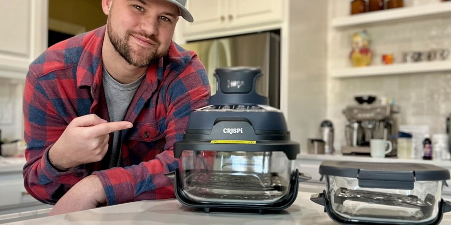 man pointing to ninja crispi and container on counter