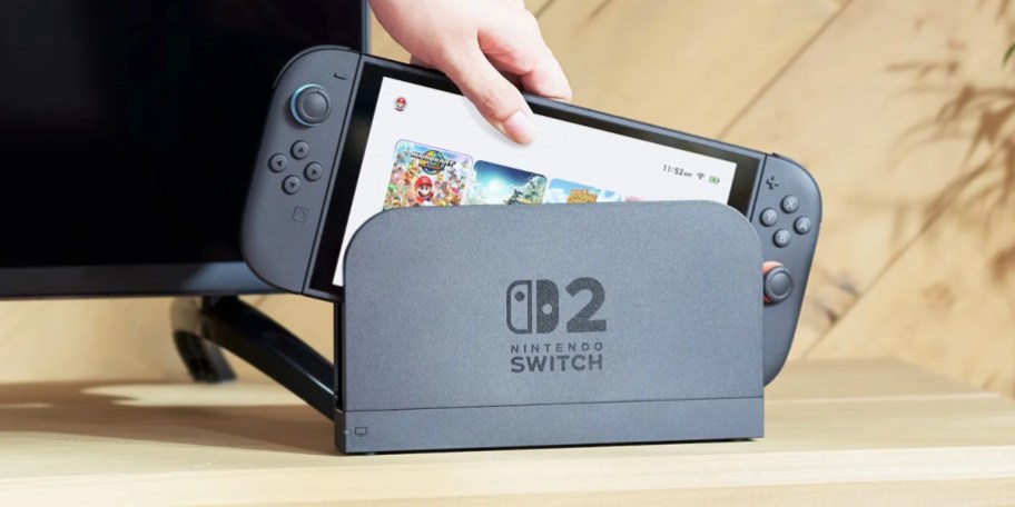 hand putting nintendo switch into dock on table