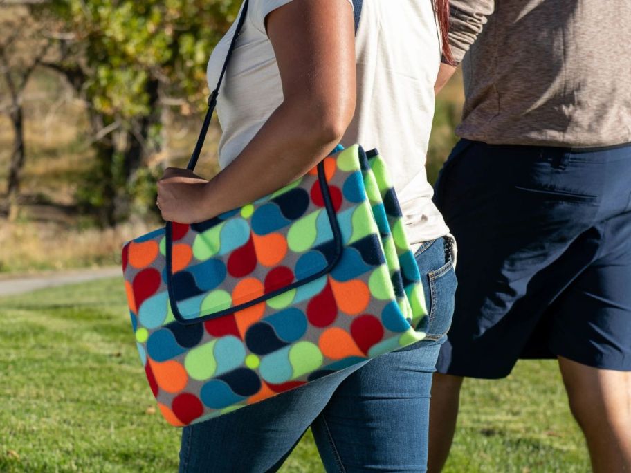 woman carrying outdoor blanket outside