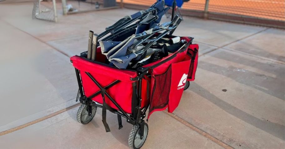 red Ozark Trail Camping Utility Wagon w/ Tailgate 21" on pavement at game filled with equipment