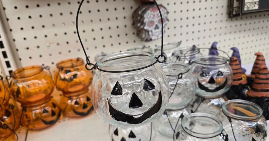 person holding up clear pumpkin tea lite jar