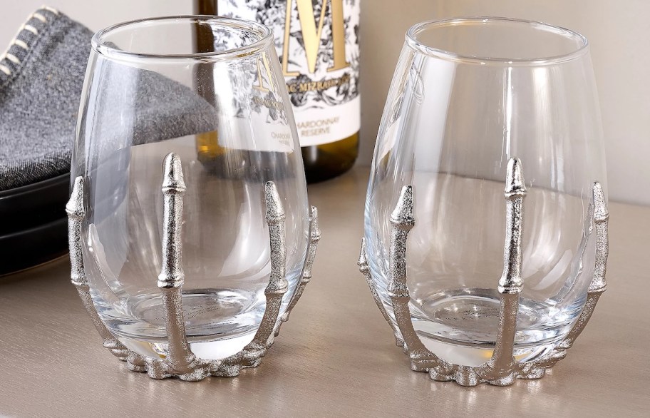 skeleton hand stemless wine glasses on table