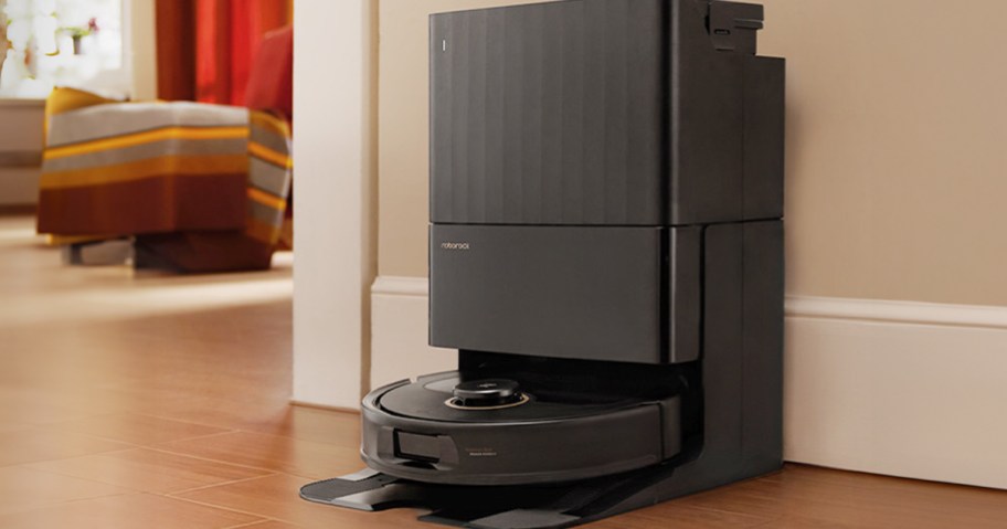 black roborock robot with dock on hardwood floor