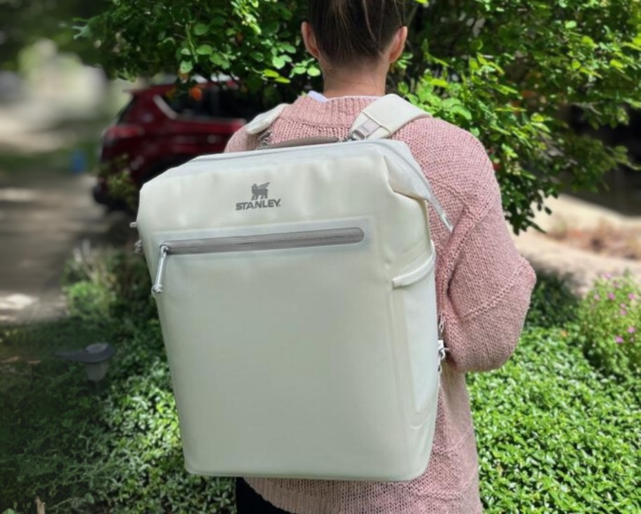 a woman wearing a stanley midi backpack cooler
