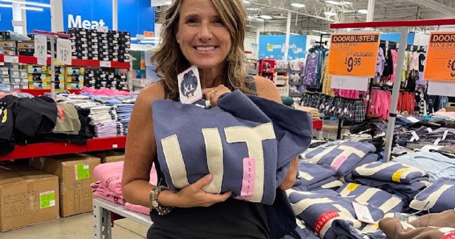 woman holding up a blue UT sweatshirt
