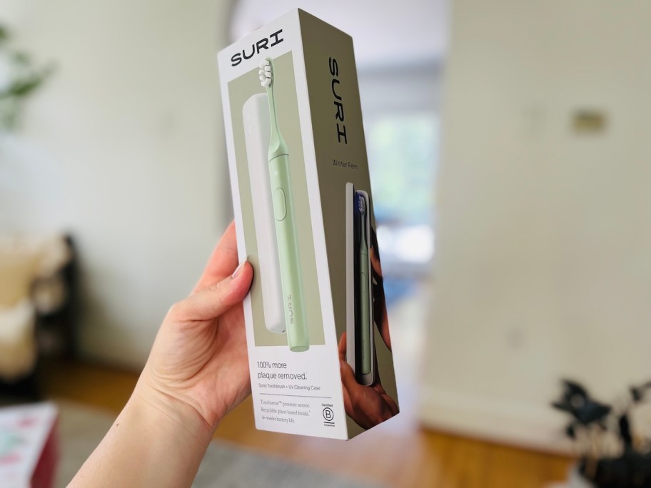 hand holding suri electric toothbrush