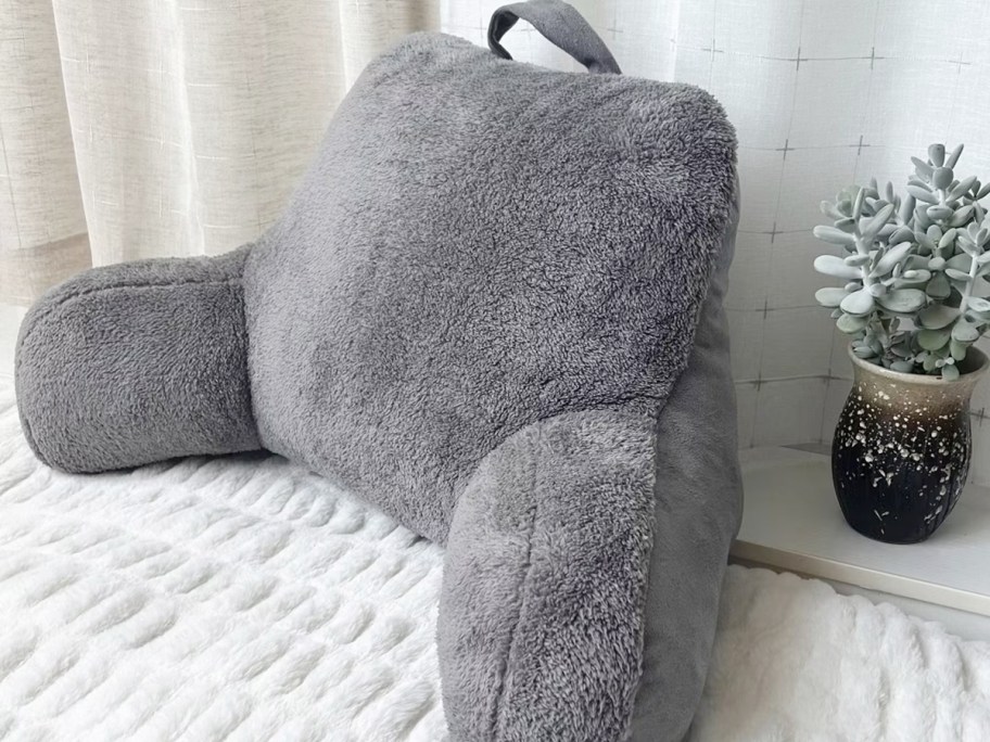 gray bedrest pillow on bed 