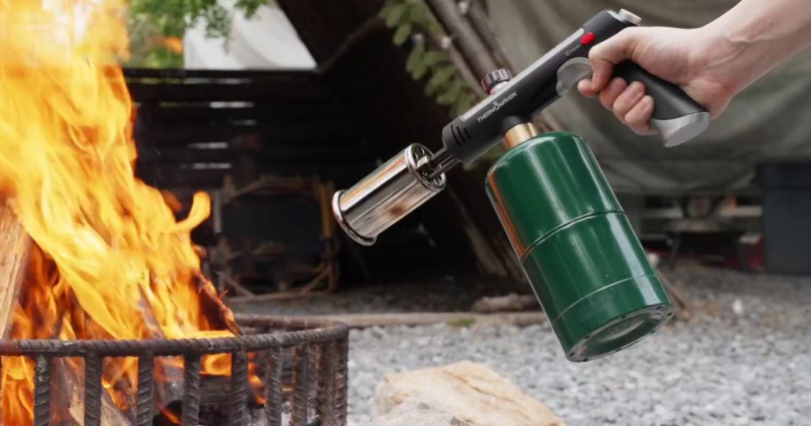 person using torch to light a fire