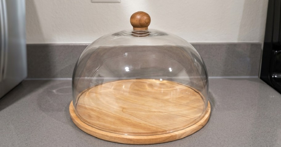 glass display case with wood base on kitchen counter