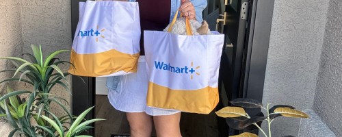 woman holding two walmart plus delivery bags on her doorstep