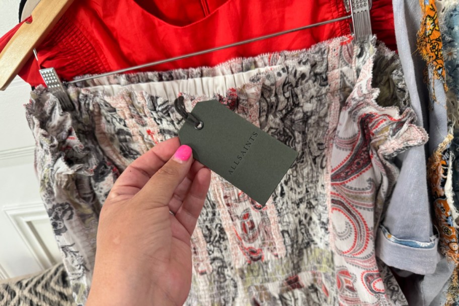 hand holding all saints tag on skirt