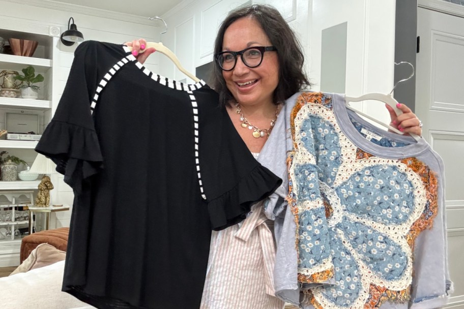 woman holding black and paisley shirts