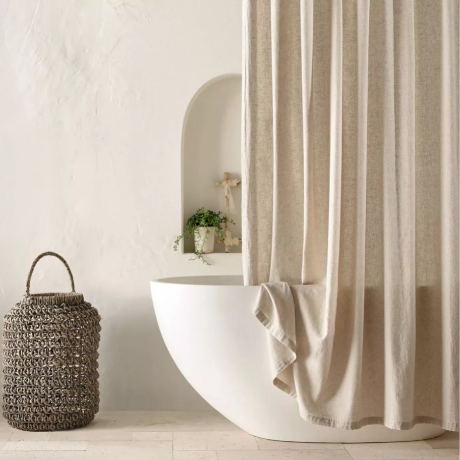 a tub with a tan shower curtain