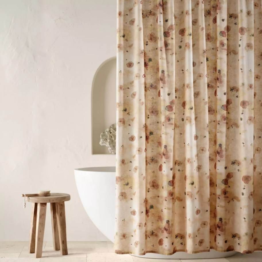 a tub with a tan floral shower curtain