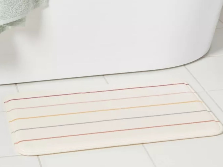 a striped bathroom rug by a tub