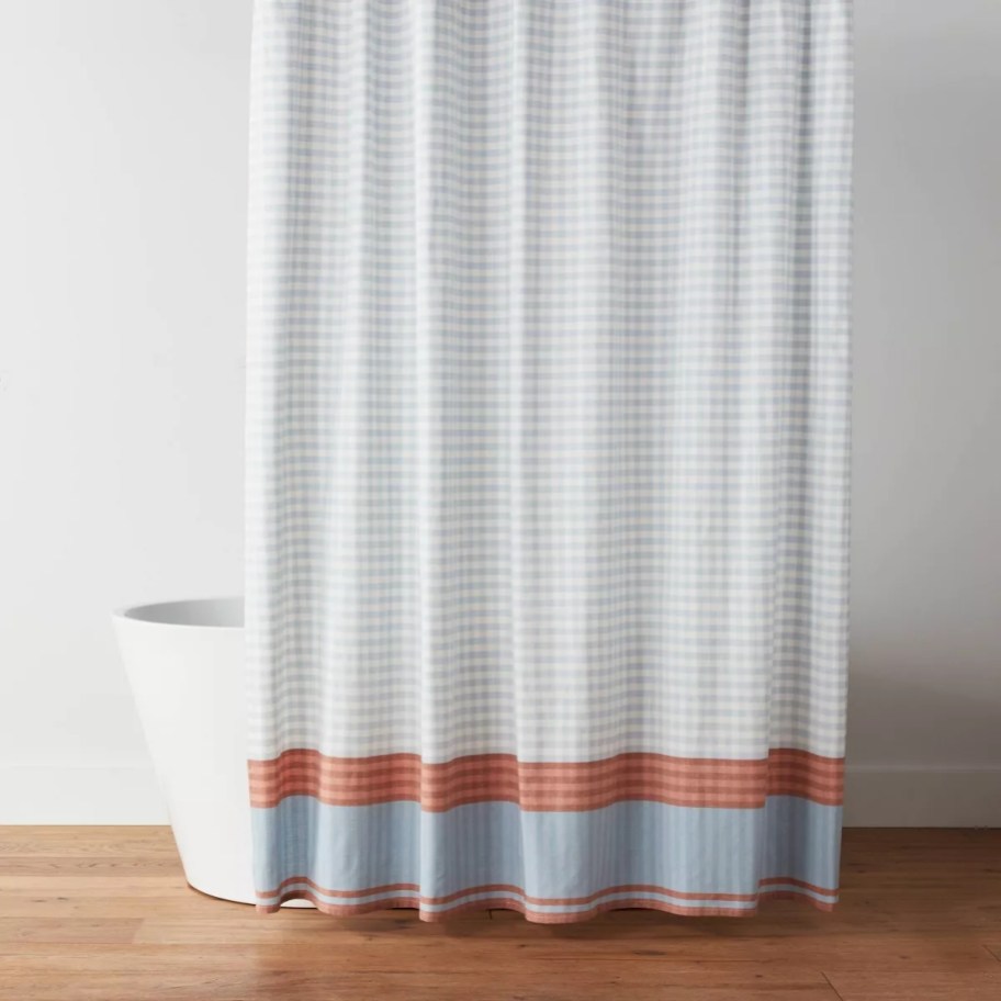 a tub with a blue gingham shower curtain