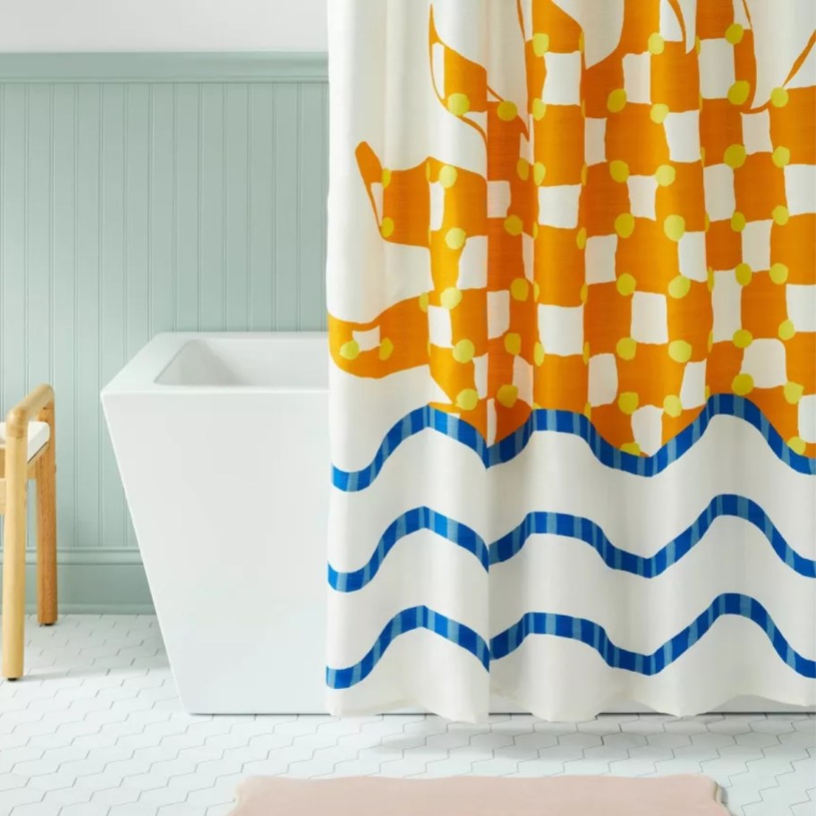 a shower curtain with a sun and wave print in a bathroom
