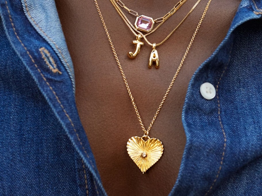woman's neck wearing several necklaces 