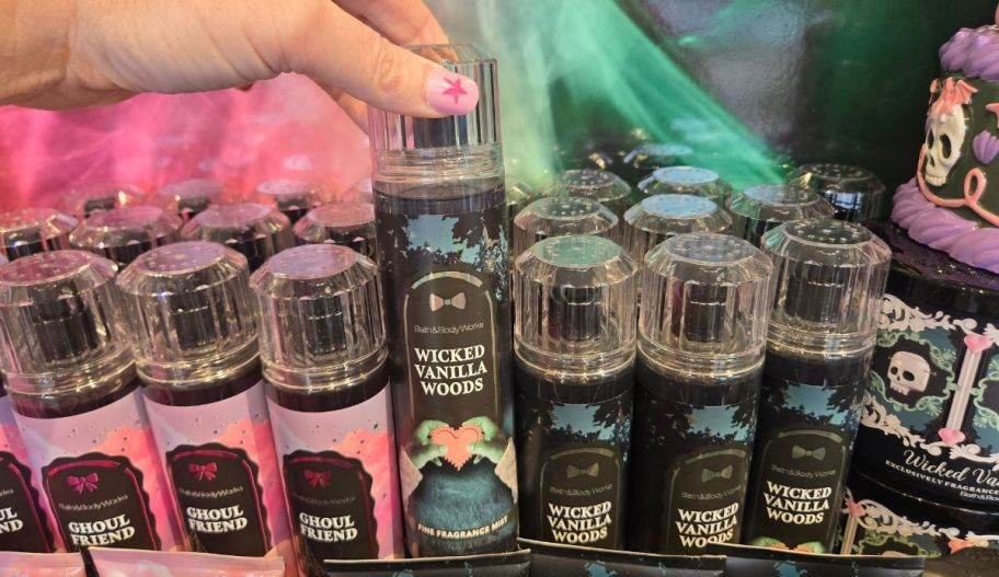 womans hand grabbing a bottle of bodymist