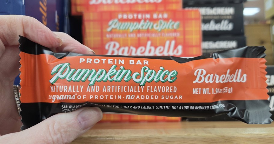 hand holding up a Barebells Pumpkin Spice Protein Bar