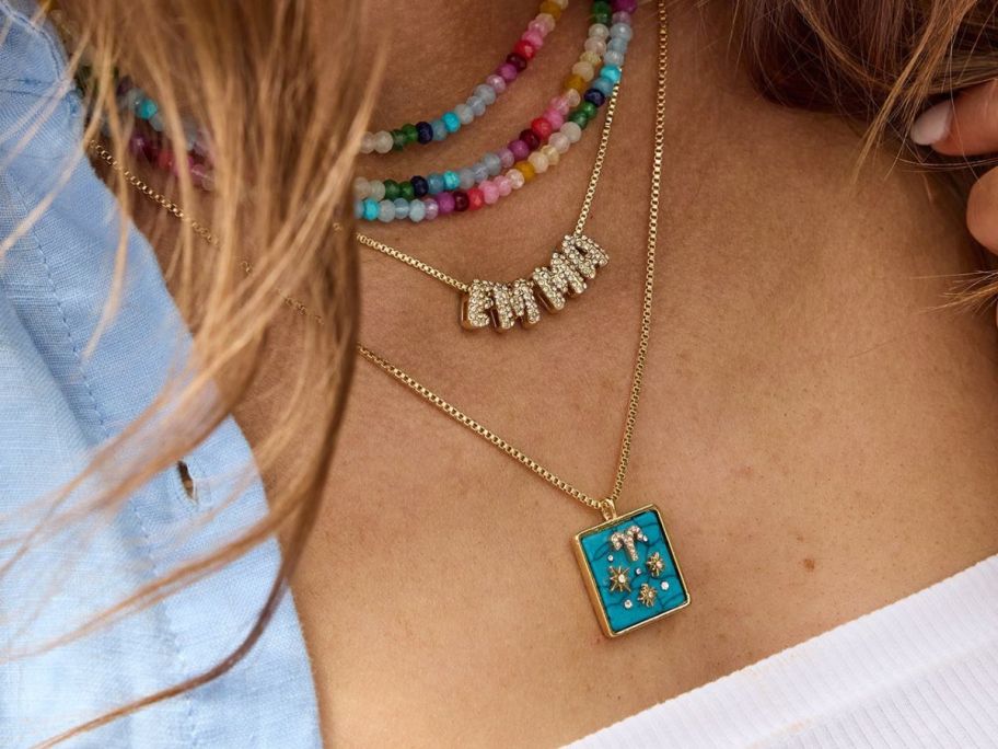 BaubleBar Semi-Precious Zodiac Pendant Necklace layered with other colorful necklaces