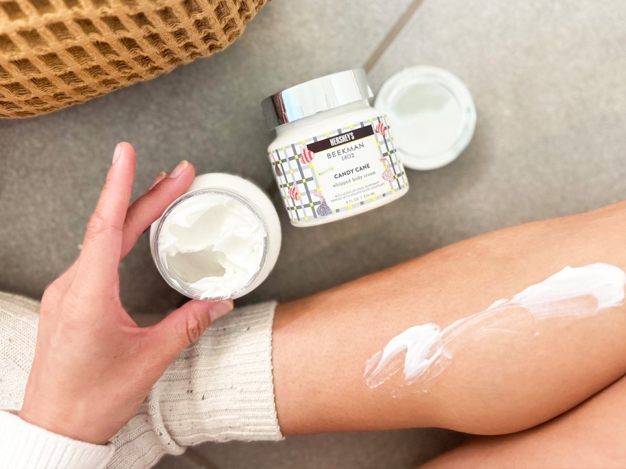 woman applying body cream to her leg