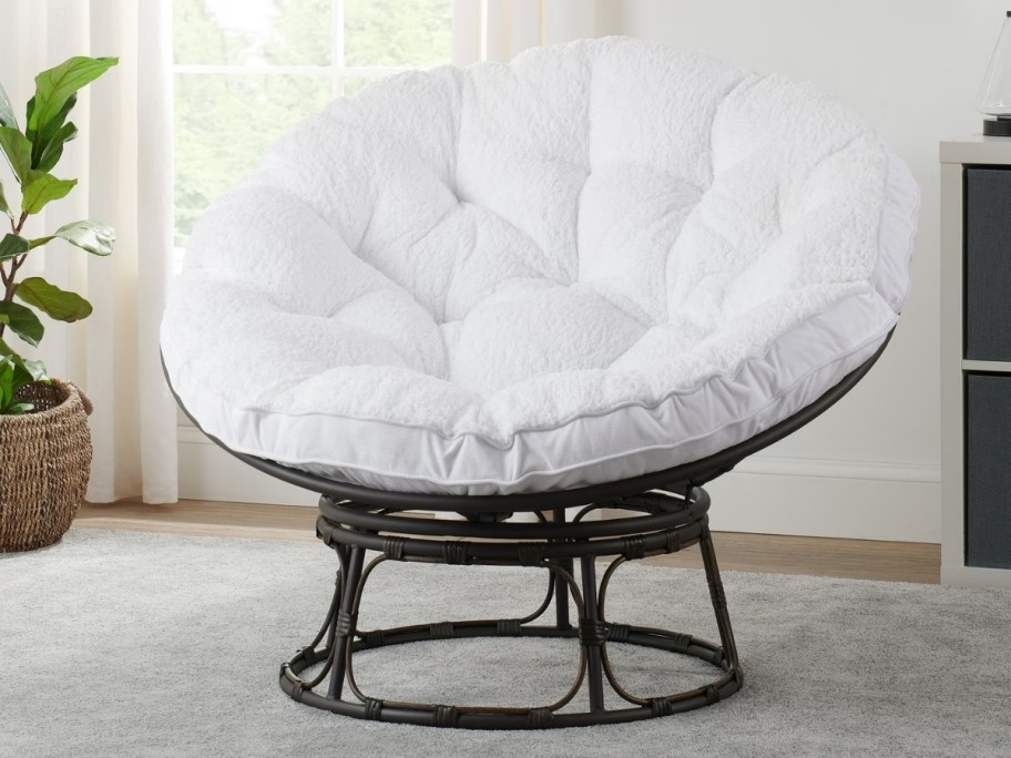 a papasan chair with a white boucle coushion