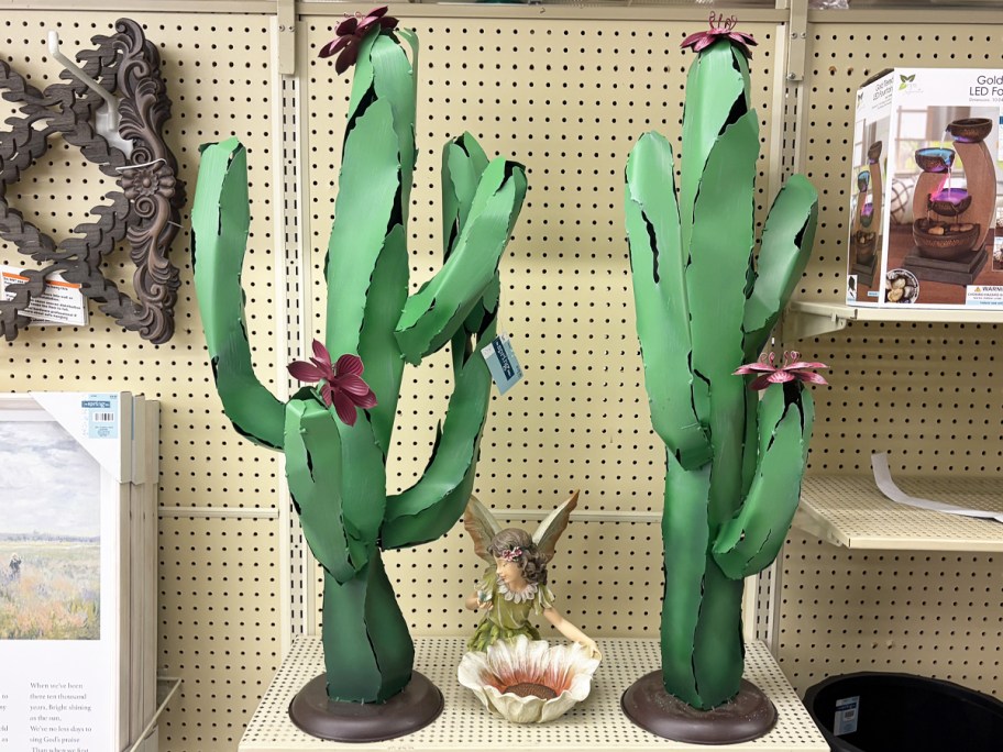 two green Cactus Metal Garden Statues on store shelf